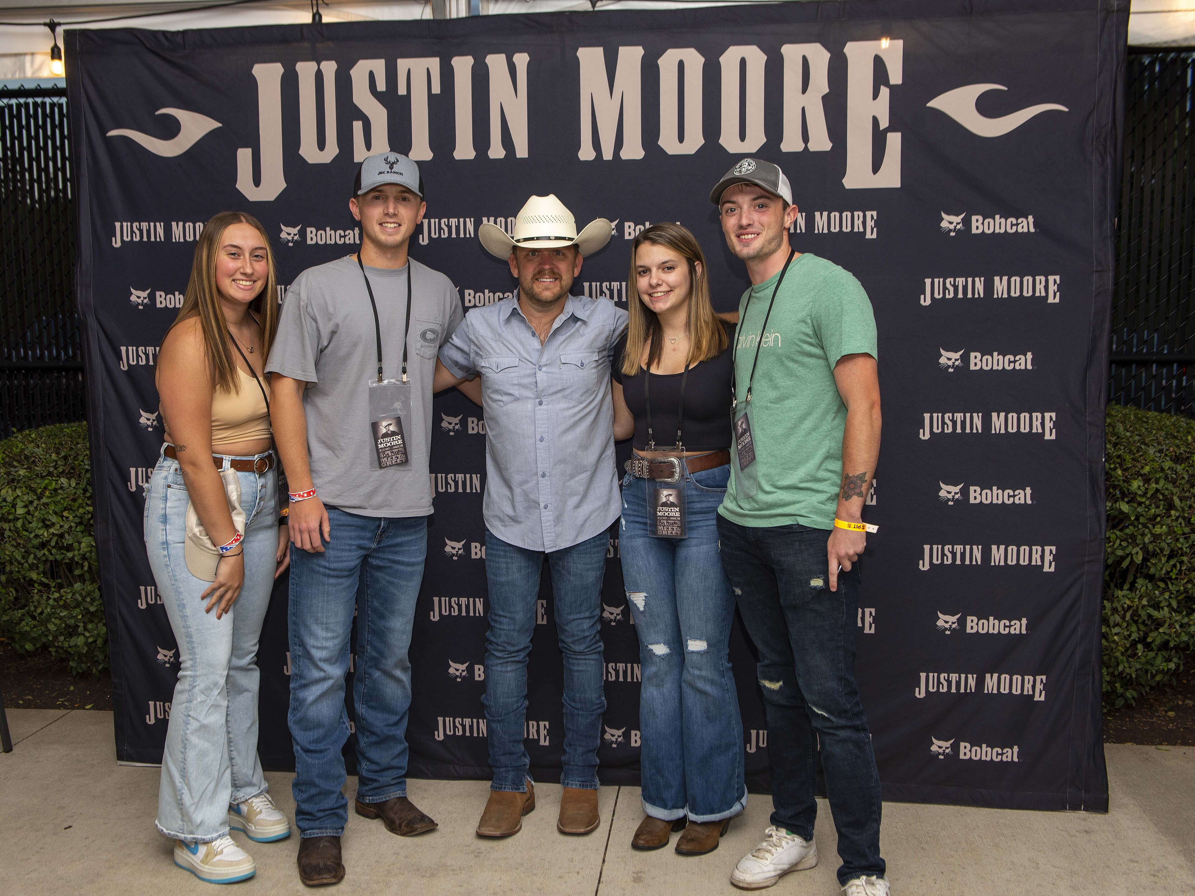 (From left) Airman 1st Class Payge Silvis, Senior Airman Logan Lescoe, country music artist Justin Moore, Senior Airman Amber Thompson and Senior Airman Chance Roye pose for a photo backstage during the 2023 Hometown Her