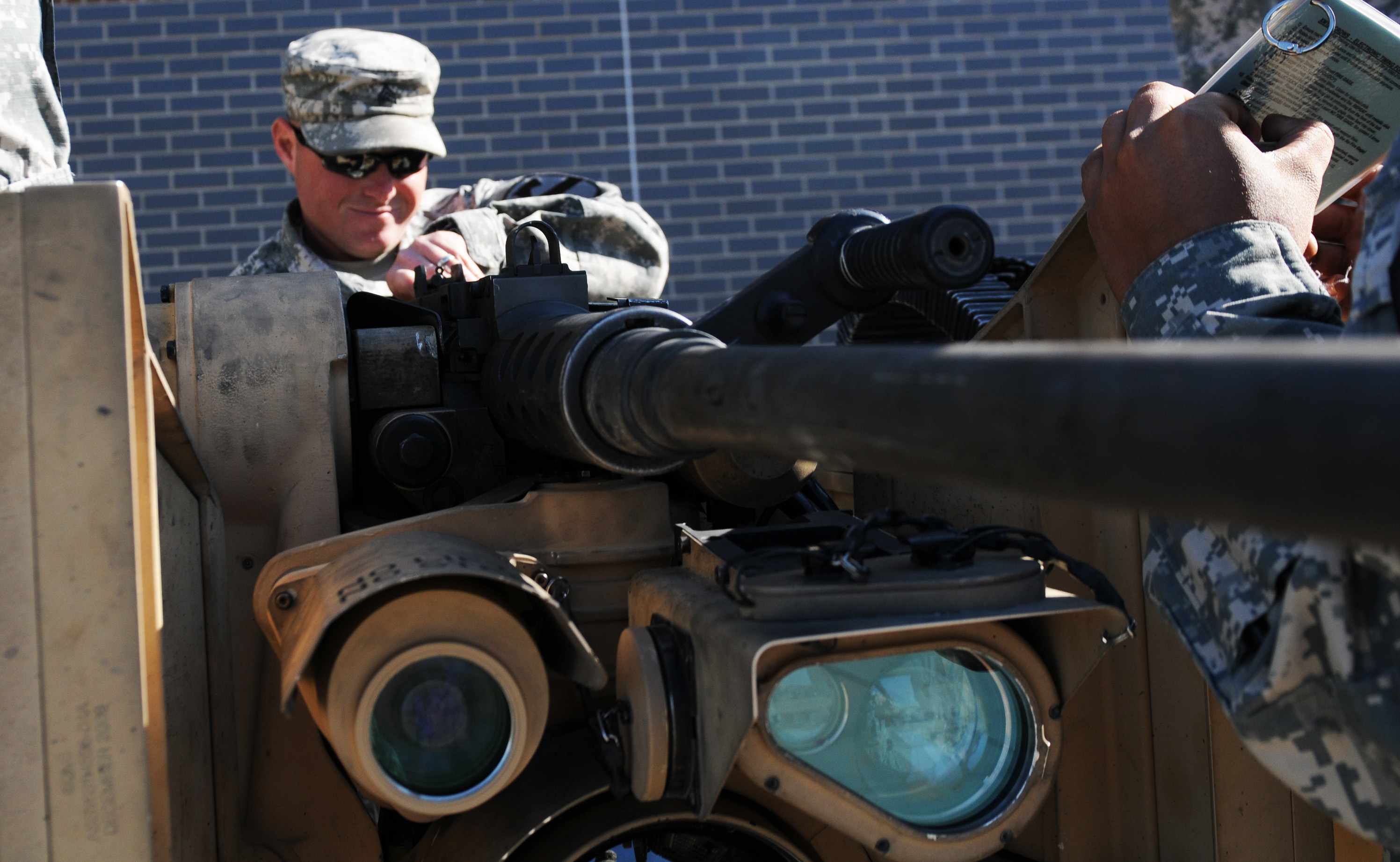 U.S. Army Sgt. Billy Herrington, a cavalry scout with the 4th Squadron, 9th Cavalry Regiment, 2nd Brigade Combat Team, 1st Cavalry Division, assists in calibrating a .50-cal. Browning machine gun attached to an M153 Comm