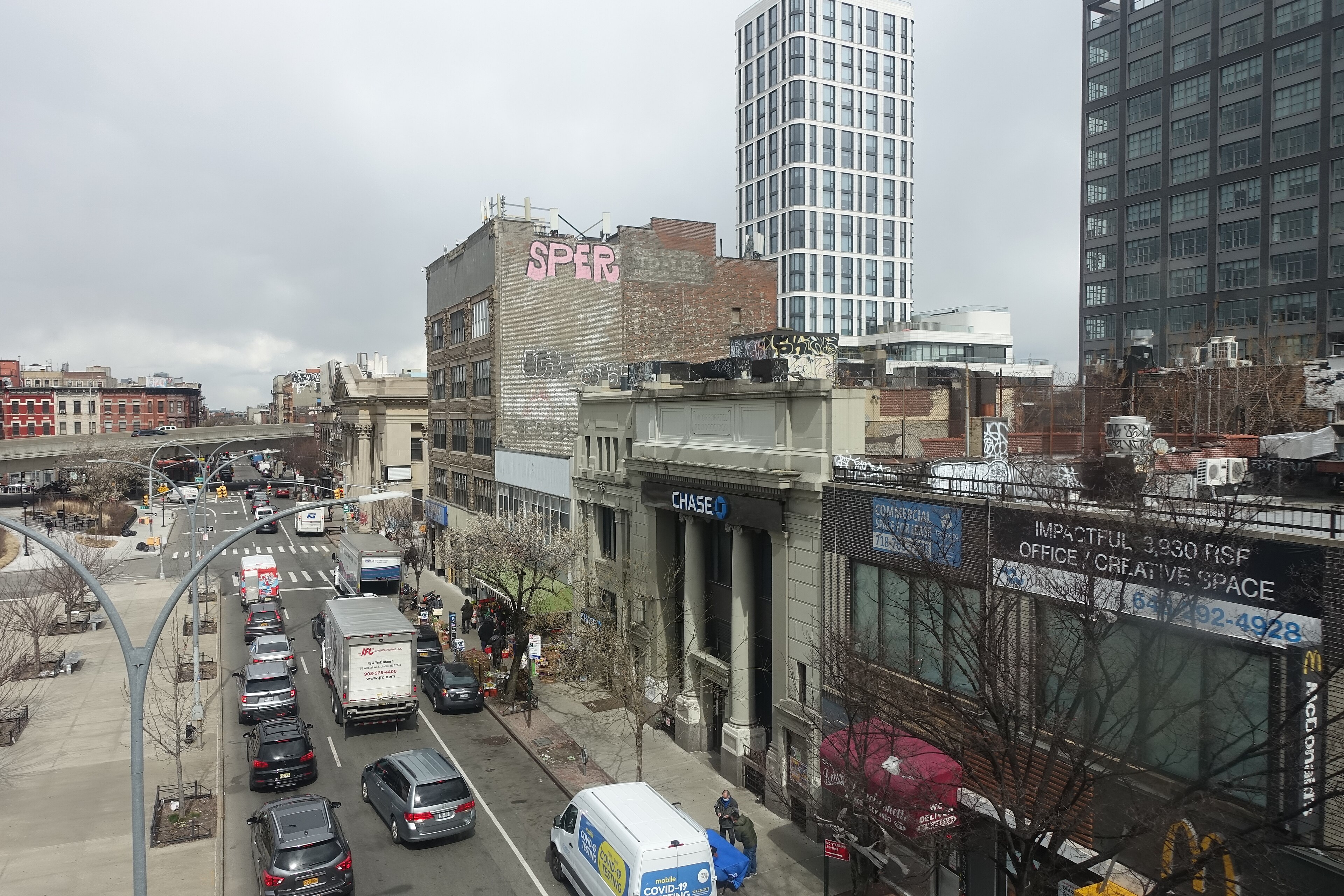 Looking north from a Broad Street-bound J local train from the Williamsburg Bridge approach at buildings along Havemeyer Street between Broadway and South 5th Street in Williamsburg, Brooklyn. This includes a Chase bank 