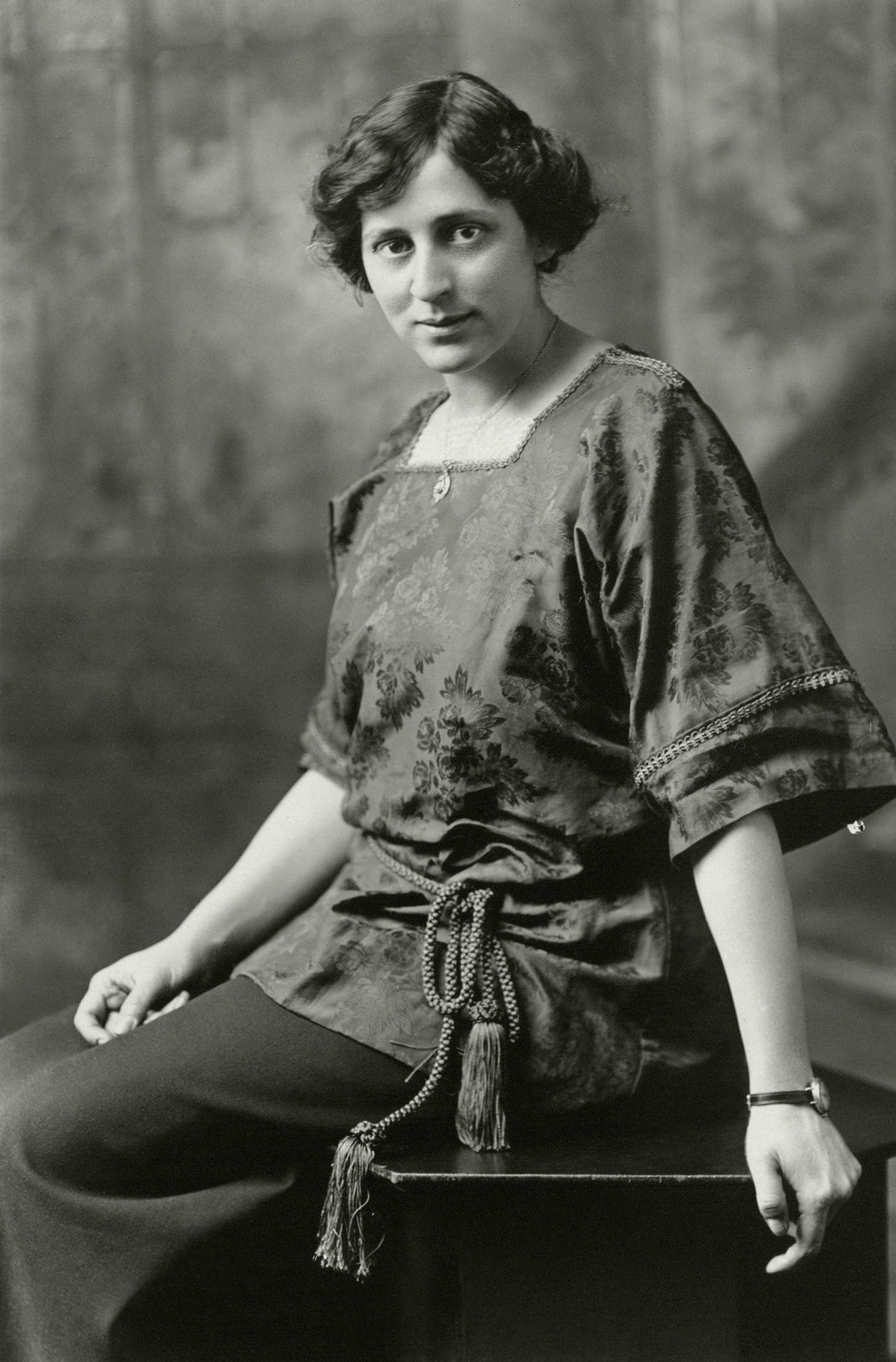 Photograph of  Crystal Eastman , during the time she was married to  Wallace J. Benedict (between 1911–1916). 4 x 6 in.  Formal portrait, three-quarter-length, seated, Crystal Eastman Benedict  [  sic  ], facing left wit