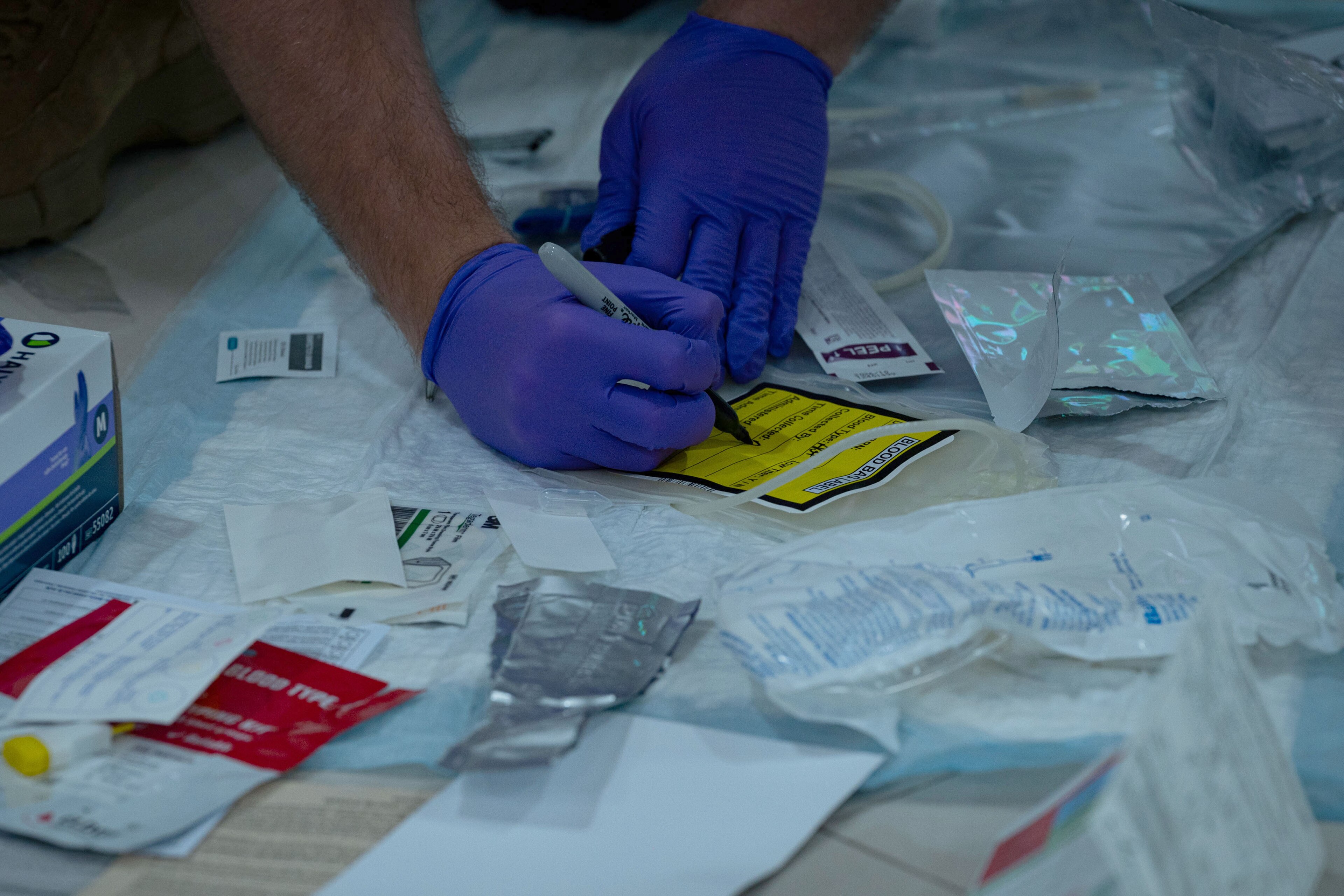 U.S. Air Force Senior Airman Matthew Webb, 336th Fighter Squadron independent duty medical technician, Seymour Johnson Air Force Base, North Carolina, labels a blood bag in preparation for a walking blood bank demonstrat