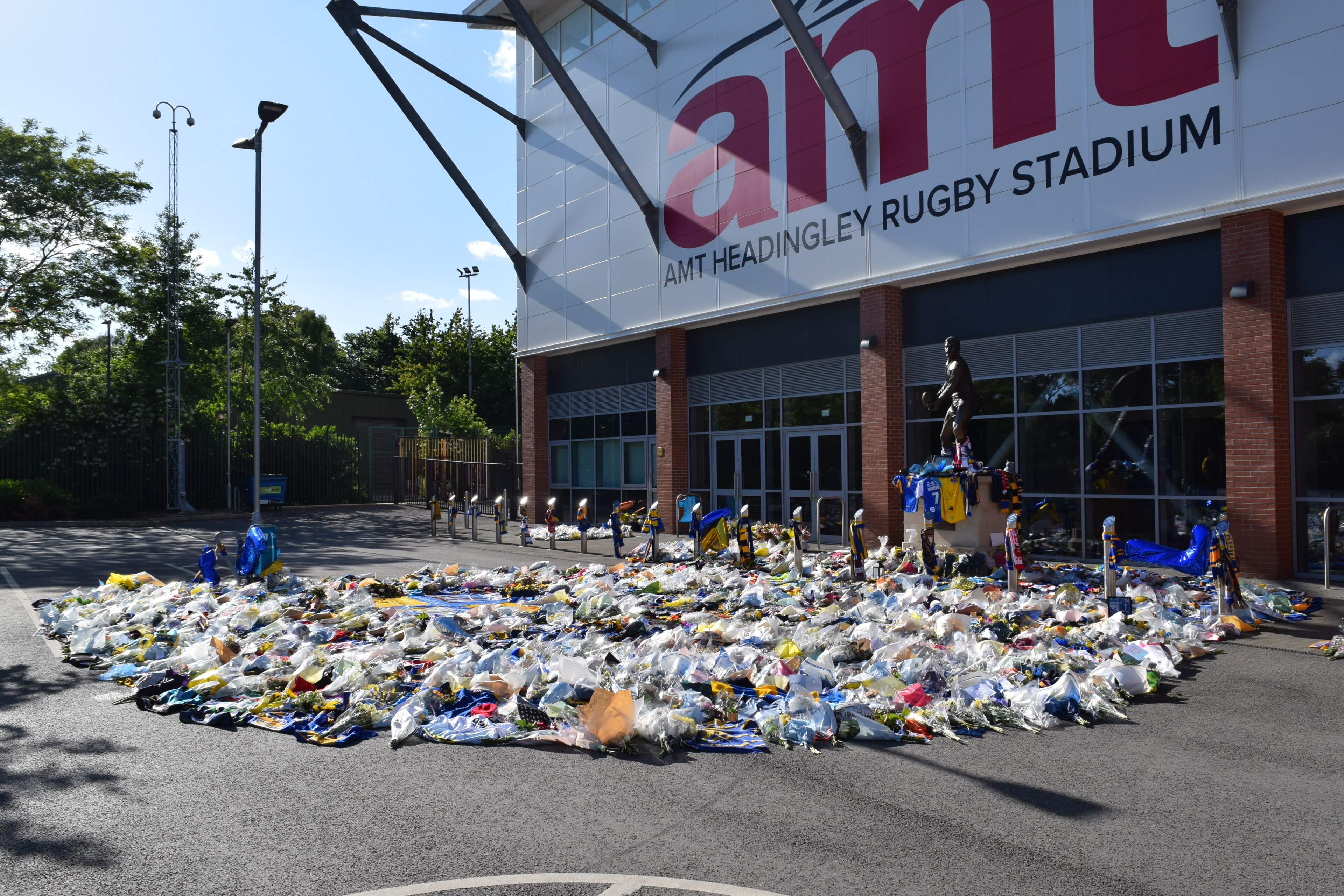 Rob Burrow memorial by the John Holmes statue, Headingley Stadium, Headingley, Leeds, West Yorkshire.  Taken on the afternoon of Saturday 8th June 2024.