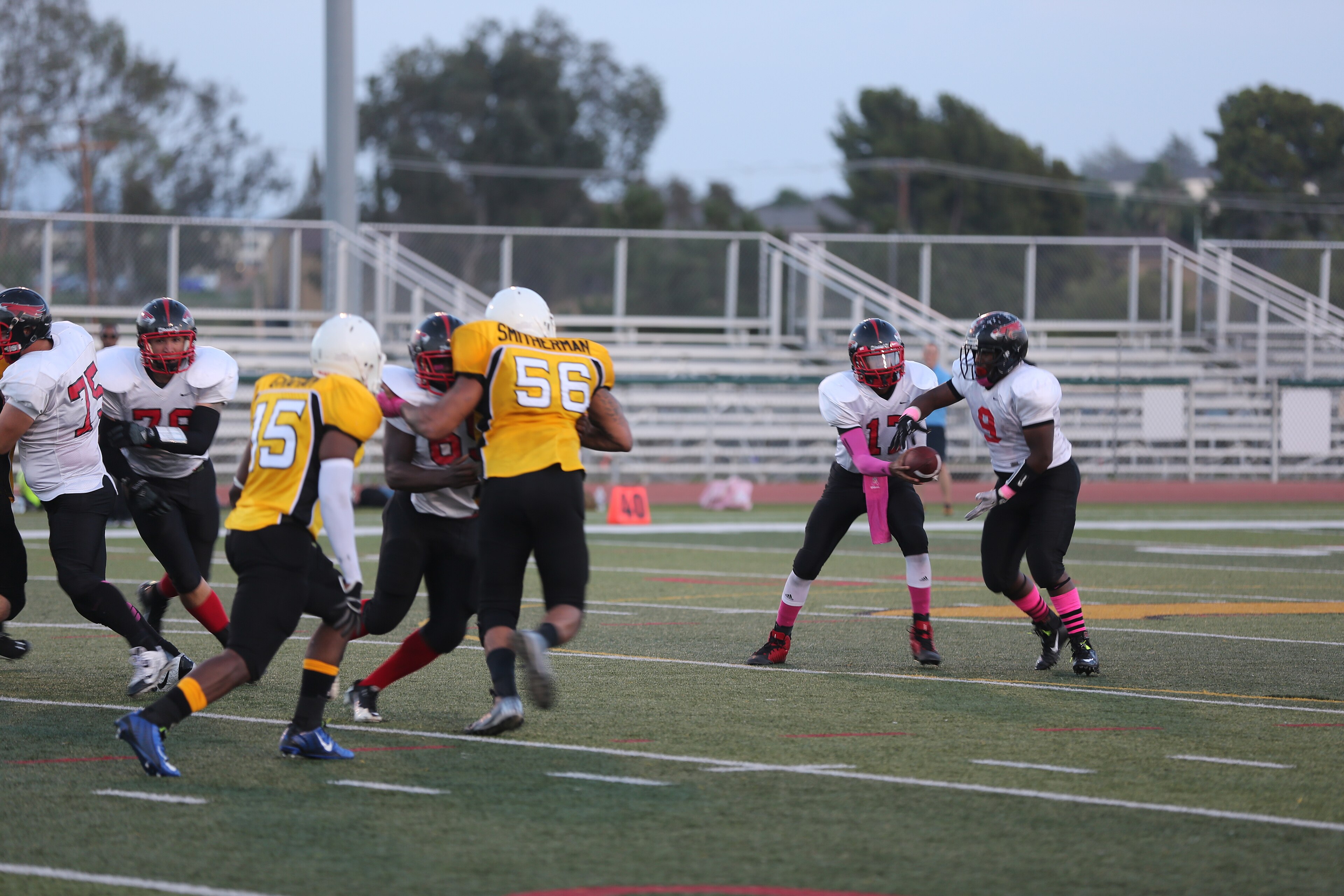 Lance Cpl. Jabari Moore, Marine Corps Air Station Miramar Falcons’ quarterback, hands the football off to Petty Officer 3rd Class Patrick Williams, MCAS Miramar Falcons’ fullback, during a football game against the 1st M
