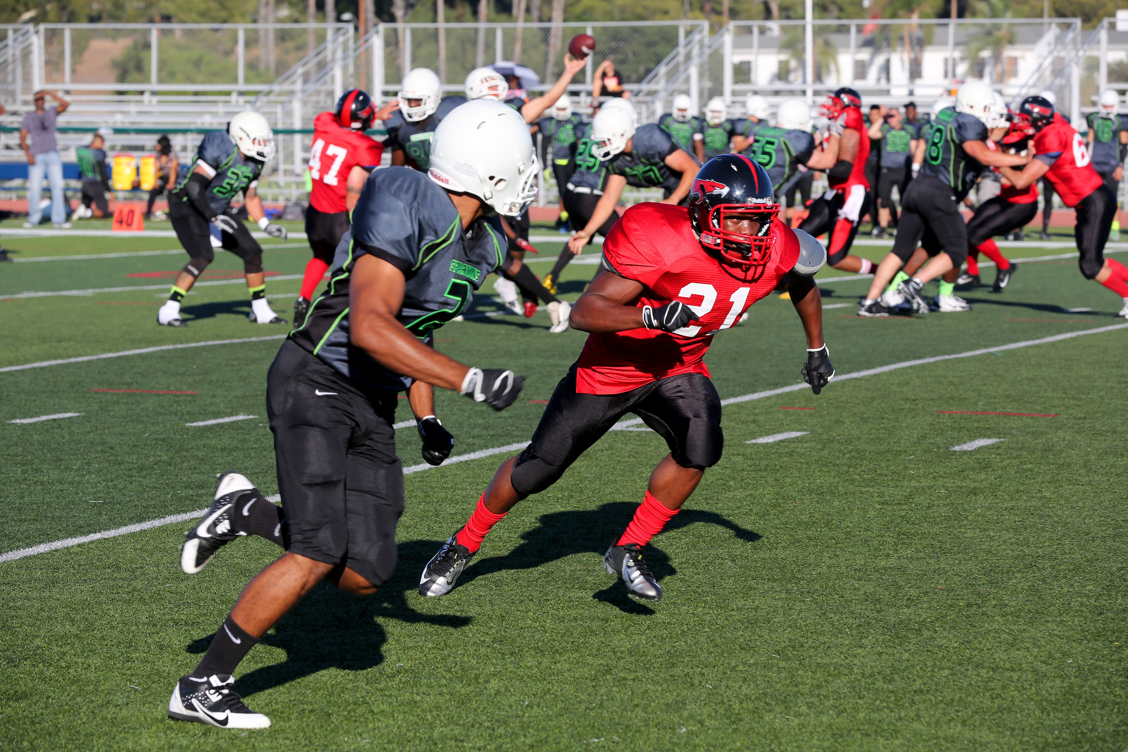 Lance Cpl. Elvis Liburd, right, a Marine Corps Air Station Miramar Falcons’ defensive back, covers a Marine Corps Base Camp Pendleton Headquarters Support Battalion Spartan during a football game at Paige Field House abo