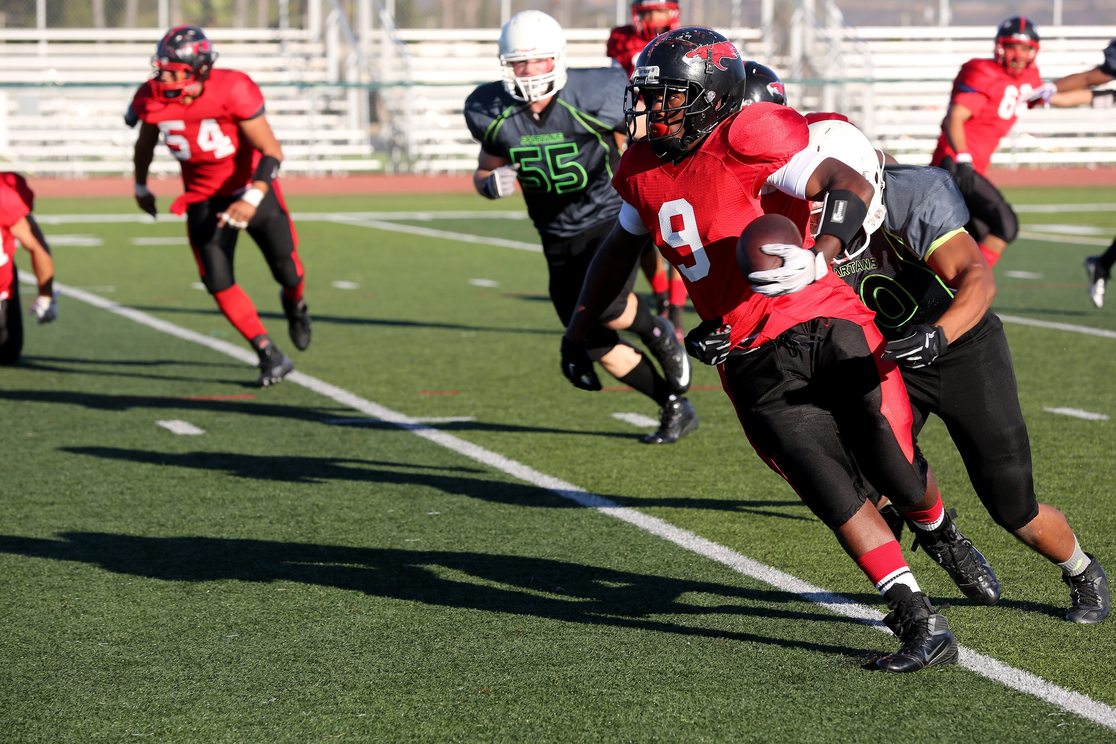 Petty Officer 3rd Class Patrick Williams, Marine Corps Air Station Miramar Falcons’ fullback, sheds a Marine Corps Base Camp Pendleton Headquarters Support Battalion Spartans defender during a football game at Paige Fiel