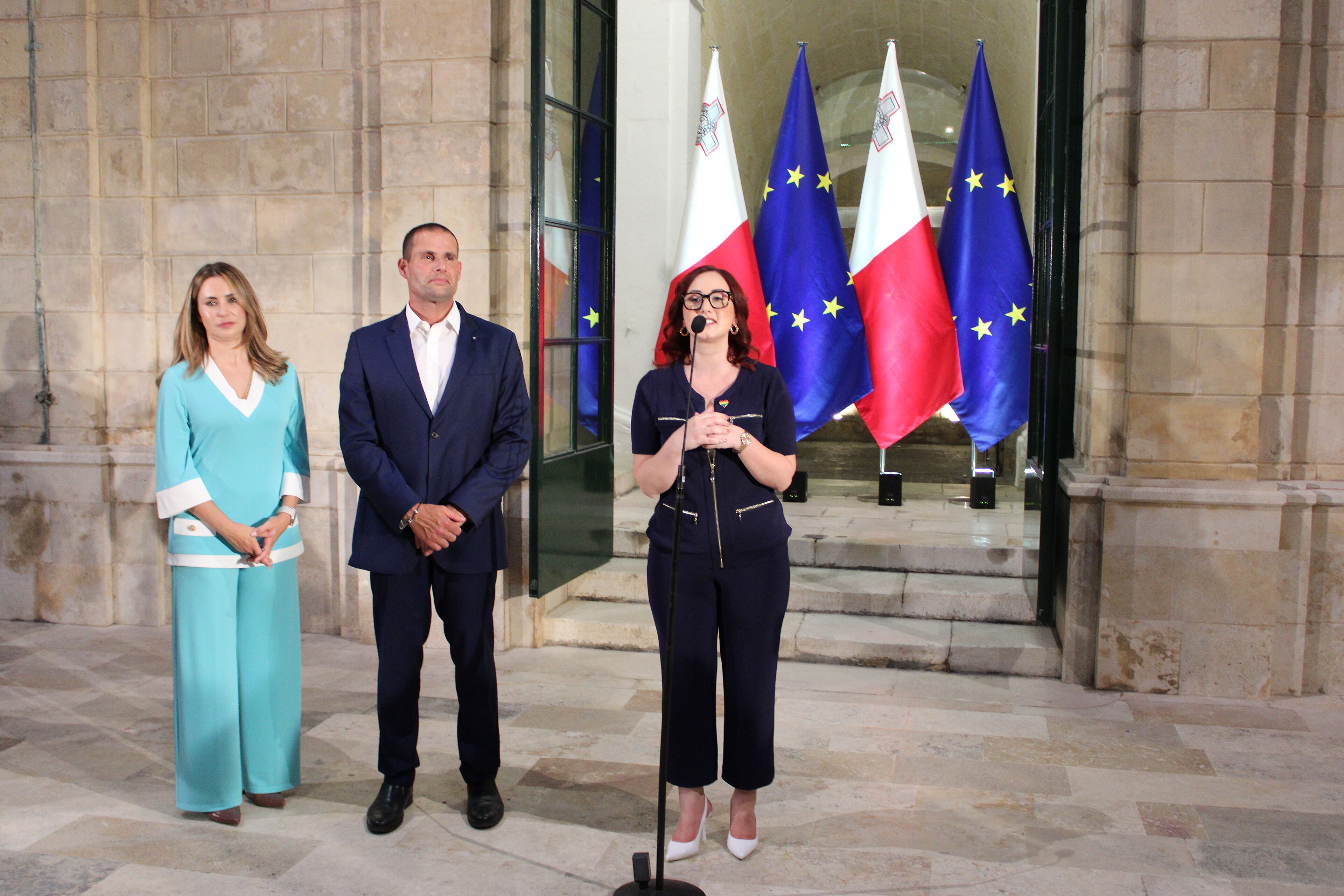 Rebecca Buttigieg speaking at Europride 2023 Malta. Prime minister Robert Abela and his wife Lydia Abela are standing at her side.