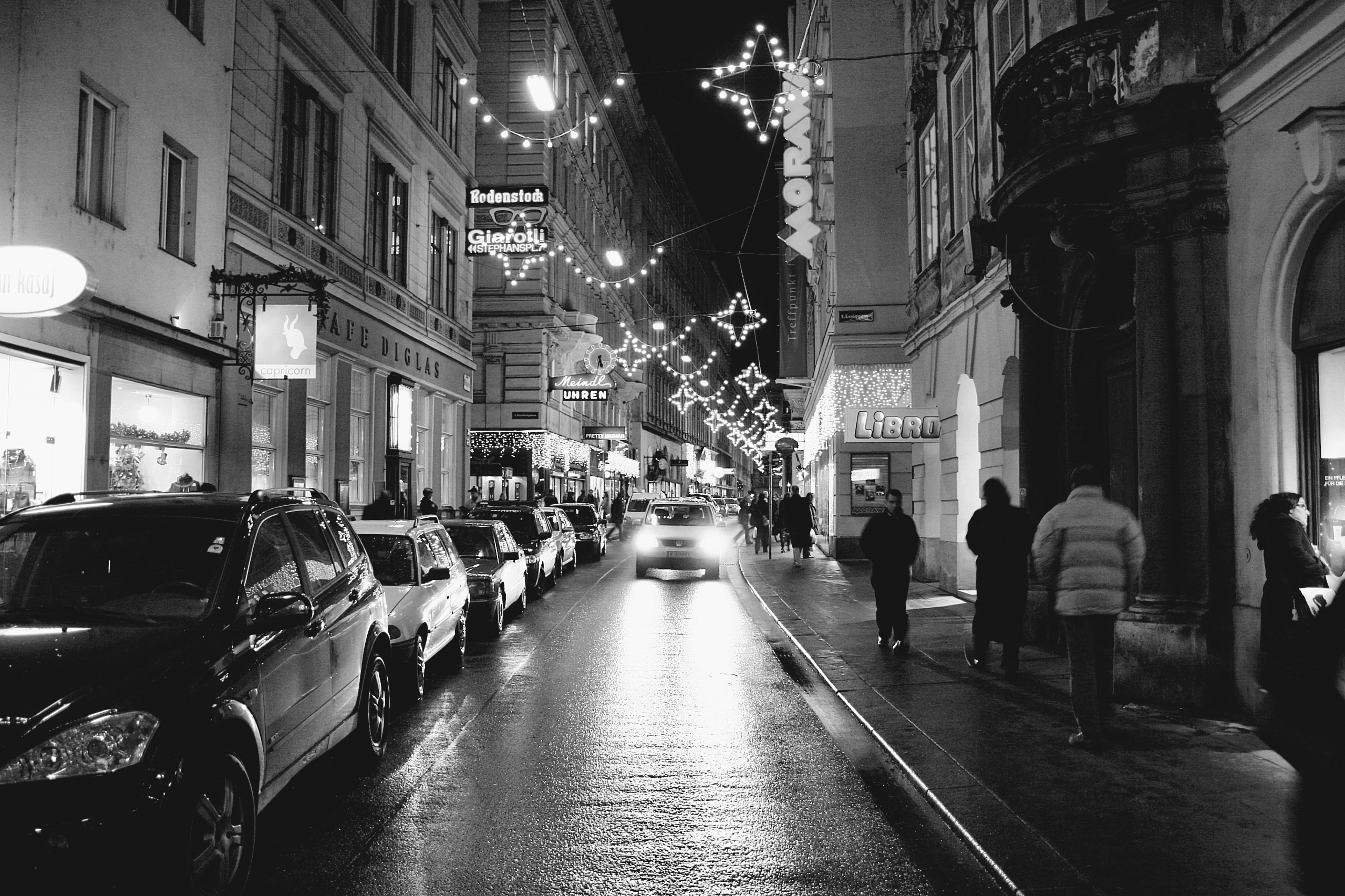 Black and white photo of Christmas lights in  Wollzeile  street in Vienna Old Town, Austria. City Christmas decorations in Europe